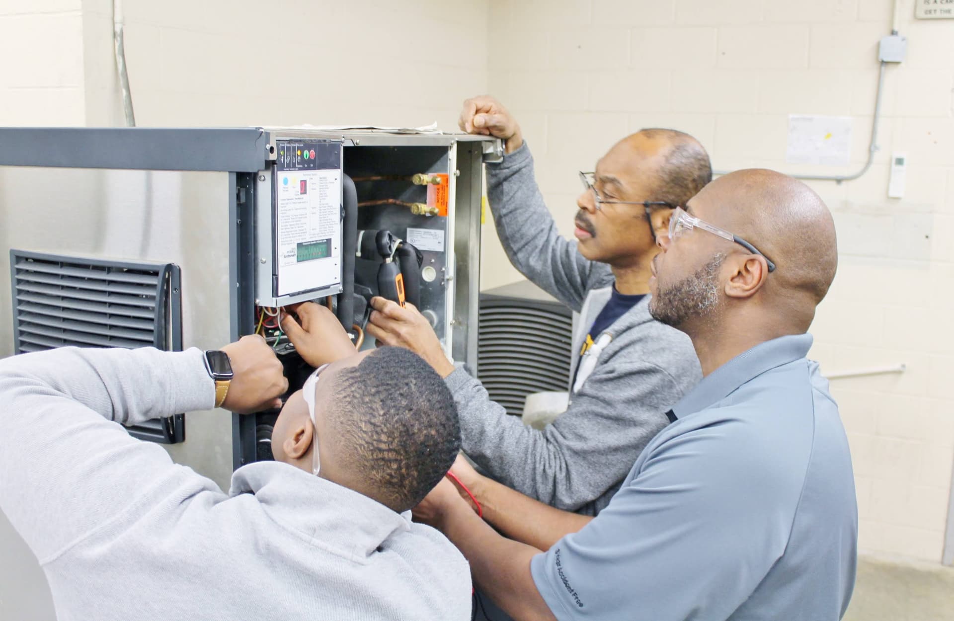 Students servicing an HVAC unit