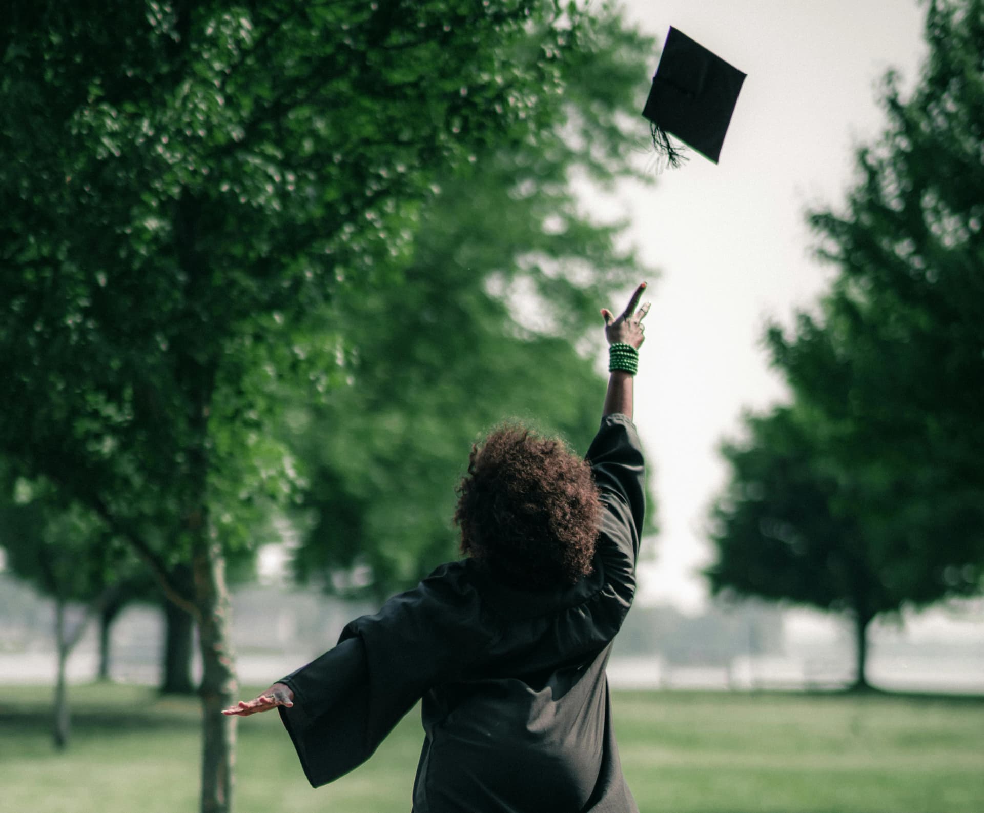 a graduate student is throwing het in the air